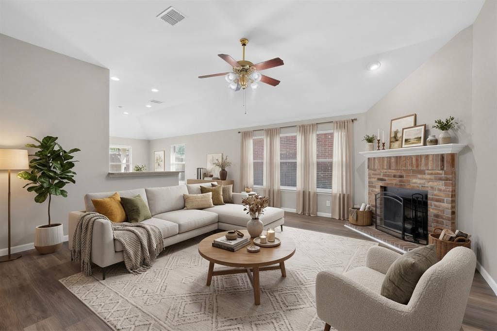 Vaulted ceilings with a ceiling fan, brick fireplace with a white mantel, recessed lighting, wood-finish flooring, and multiple windows