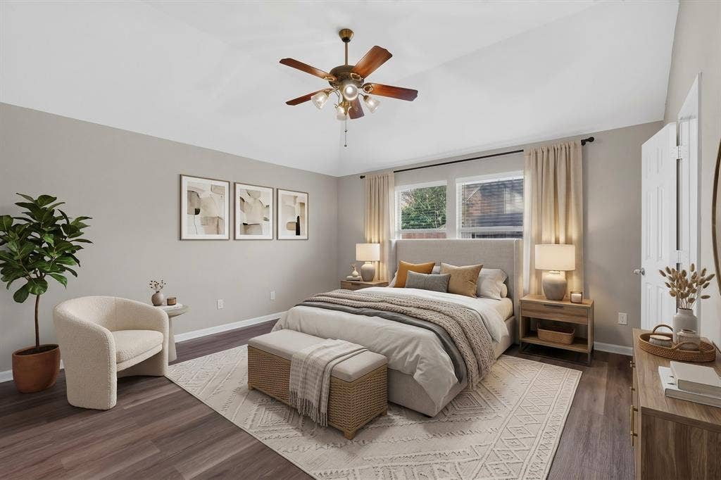 Vaulted ceiling with a ceiling fan, dual windows, and wood-finish flooring