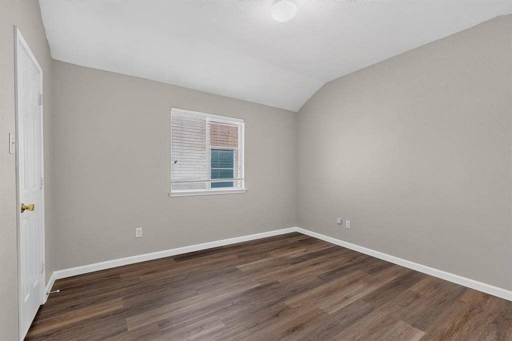 Wood-finish flooring, white trim, neutral wall color, window with blinds, and ceiling-mounted light fixture