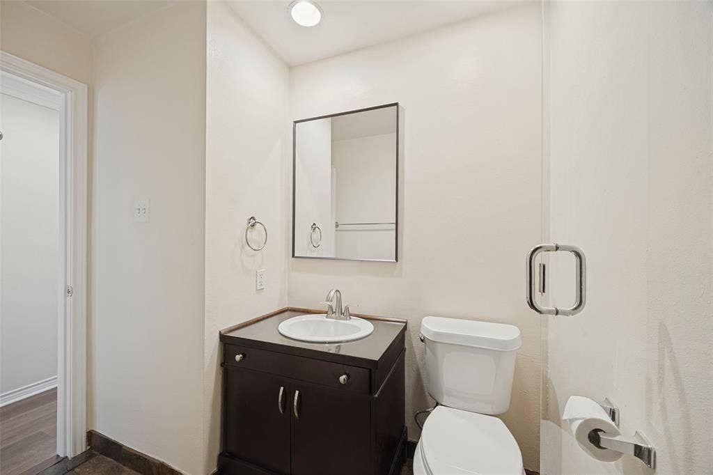 Recently replaced vanity, sink, fixtures at sink and shower, mirror, and commode.