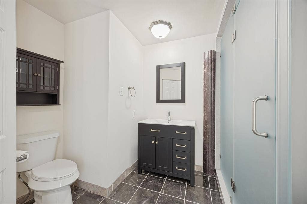 Recently renovated with a walk-in shower, vanity, sink, mirror, commode.