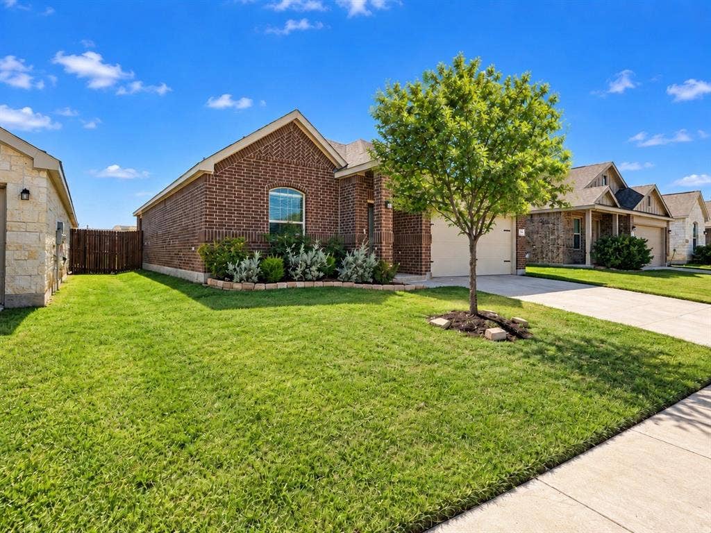 1605 River Crossing Drive, Anna, TX 75409 Brick exterior, arched window, attached garage, concrete driveway, mature landscaping