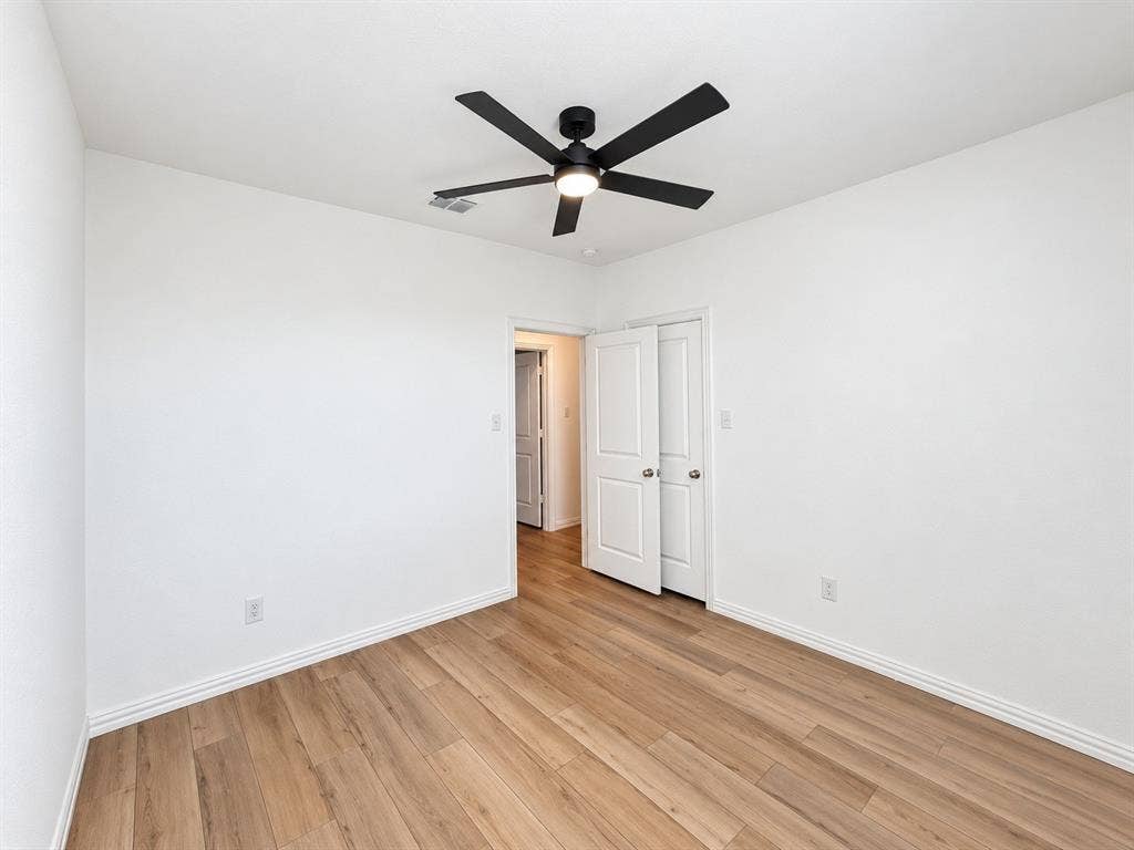 1605 River Crossing Drive, Anna, TX 75409 Wood-finish flooring throughout, white painted walls, and a modern black ceiling fan with integrated lighting