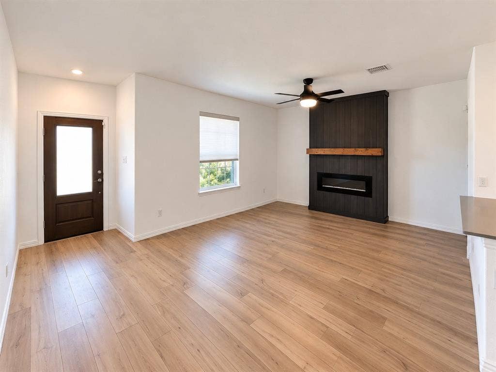 1605 River Crossing Drive, Anna, TX 75409 Recessed lighting, wood-finish flooring, dark wood-paneled fireplace surround with wood mantel, electric fireplace, and ceiling fan with integrated lighting