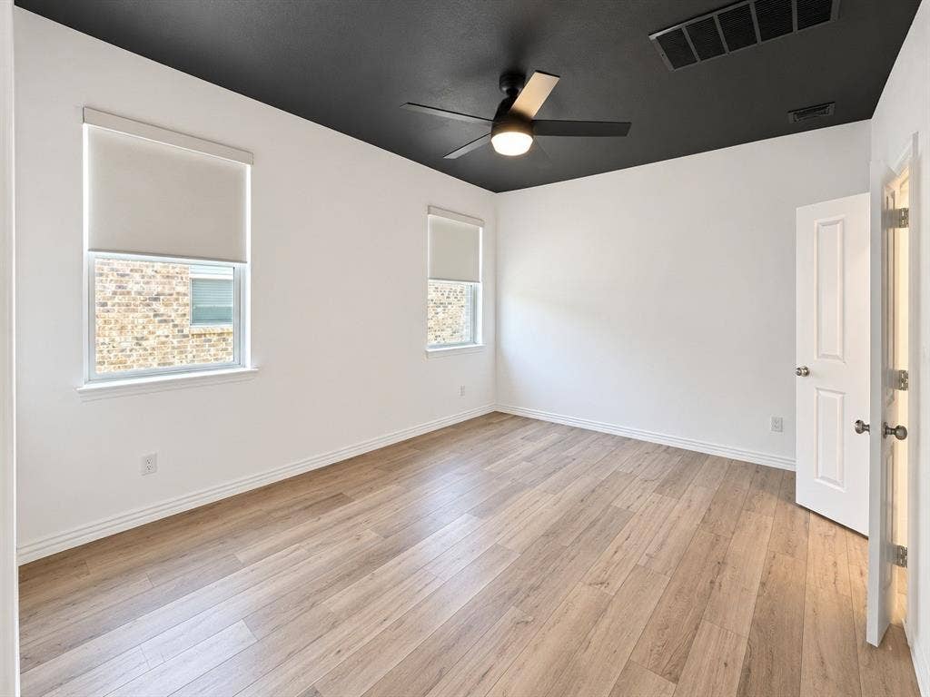 1605 River Crossing Drive, Anna, TX 75409 Wood-finish flooring, white walls, and a contrasting black ceiling with a ceiling fan