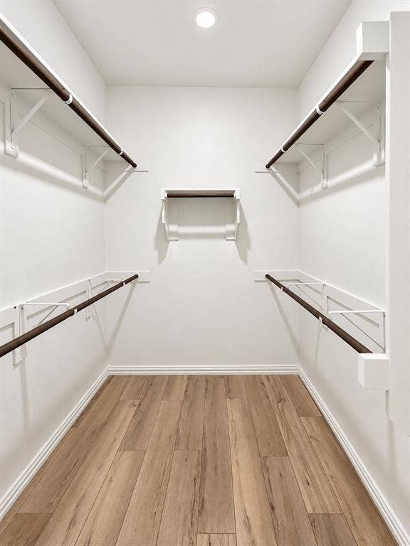 1605 River Crossing Drive, Anna, TX 75409 Walk-in closet with wood-finish flooring, recessed lighting, and white built-in shelving with hanging rods