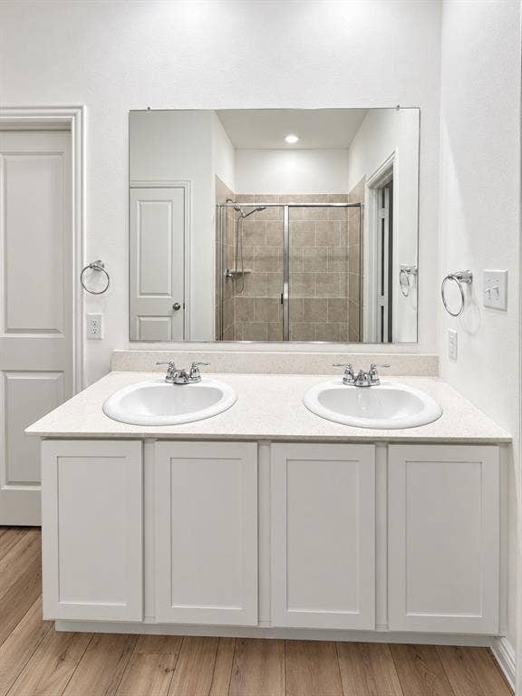 1605 River Crossing Drive, Anna, TX 75409 Dual undermount sinks with chrome faucets, white shaker-style vanity cabinetry, light-toned countertop, and a large wall-mounted mirror