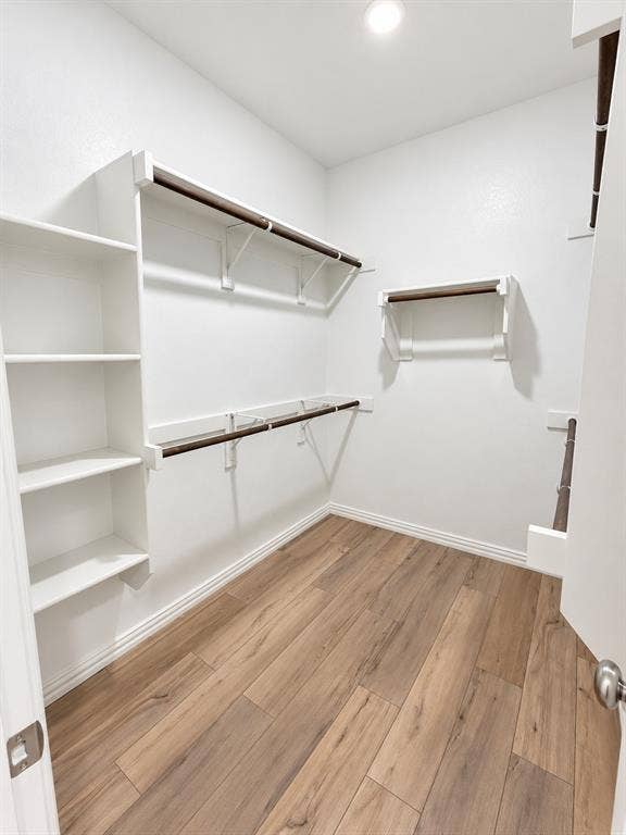 1605 River Crossing Drive, Anna, TX 75409 White interior walls, wood-finish flooring, recessed ceiling lighting, built-in shelving, and multiple hanging rods