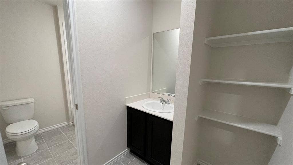 409 White Willow Drive, Nevada, TX 75173 Vanity with dark wood cabinetry, white countertop, and integrated sink