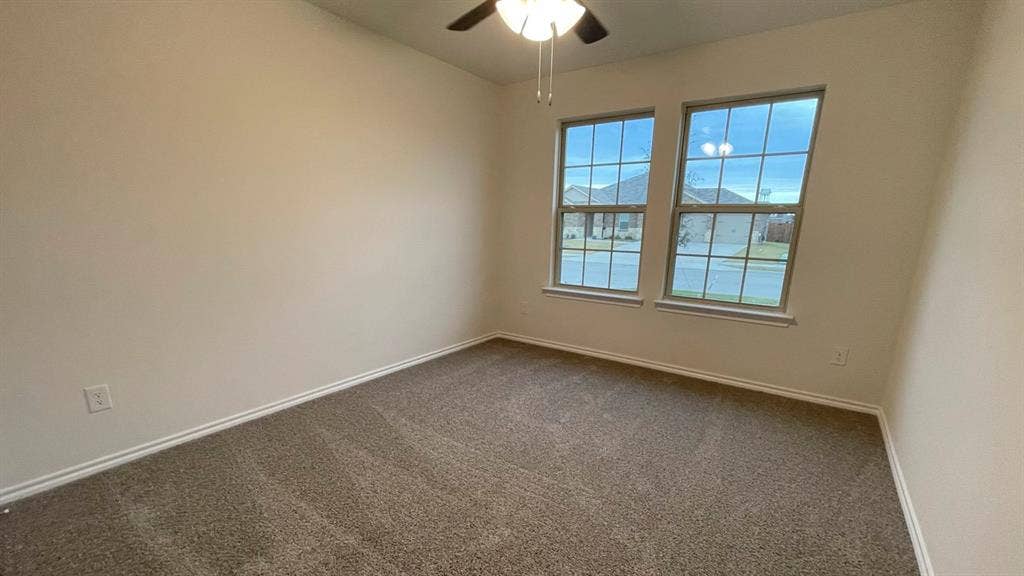 409 White Willow Drive, Nevada, TX 75173 Neutral paint palette, textured carpeting, dual pane windows, and a ceiling fan with integrated lighting
