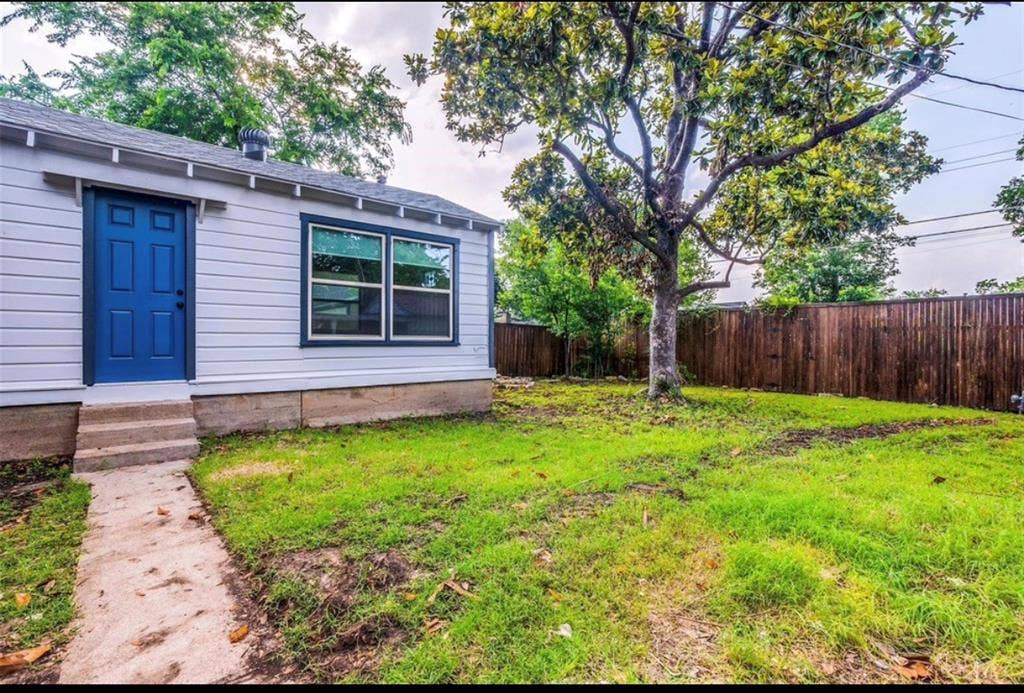 1323 Engle Avenue, Dallas, TX 75224 Exterior featuring light-colored siding, a vibrant blue entry door, and dark-trimmed windows