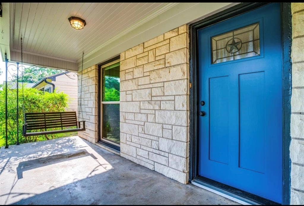1323 Engle Avenue, Dallas, TX 75224 Stone exterior with a vibrant blue entry door featuring a decorative glass insert
