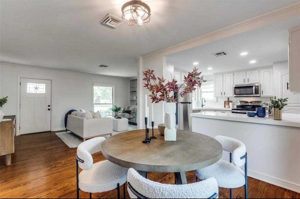 1323 Engle Avenue, Dallas, TX 75224 Hardwood-style flooring throughout, white kitchen cabinetry, stainless steel appliances, recessed lighting, and a white front entry door with decorative glass