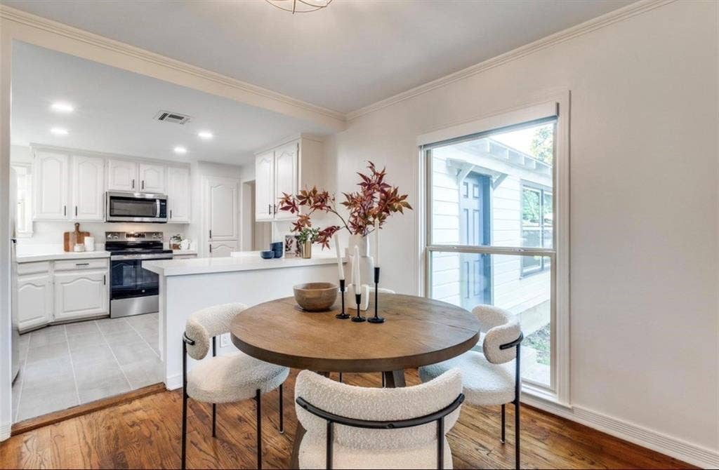 1323 Engle Avenue, Dallas, TX 75224 Wood-finish flooring, white walls, and a large window with white trim