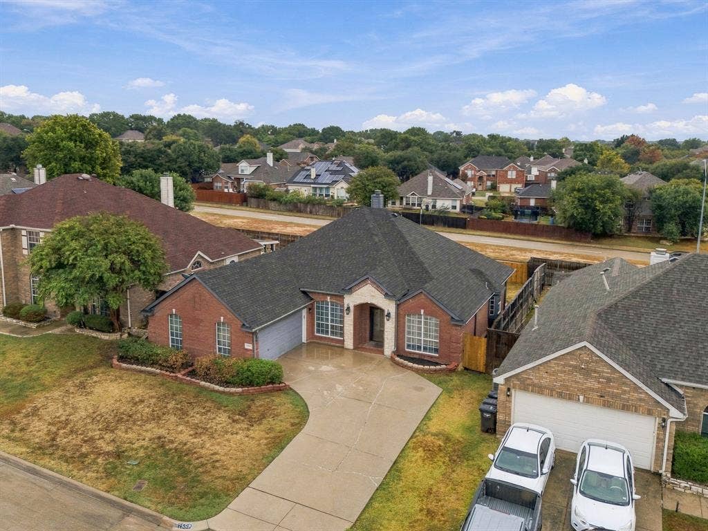 Red brick exterior with stone accents, attached garage, and landscaped front yard