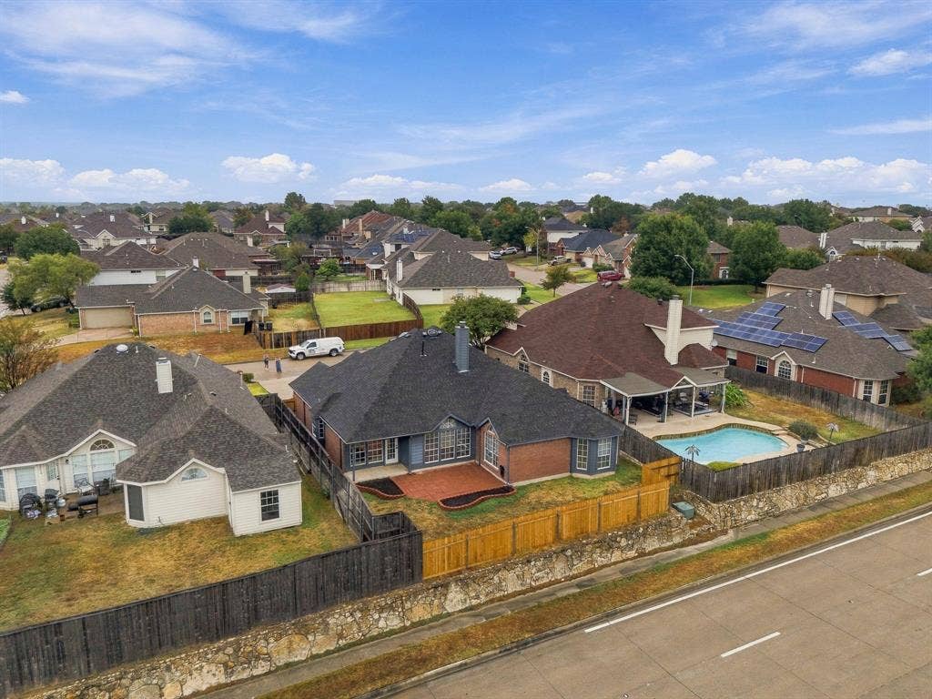 Brick exterior with an attached garage, backyard swimming pool, and wood privacy fencing
