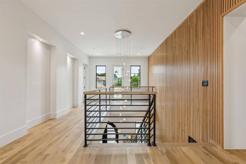 Staircase featuring wood finished floors, wood paneled accents on walls and baseboards