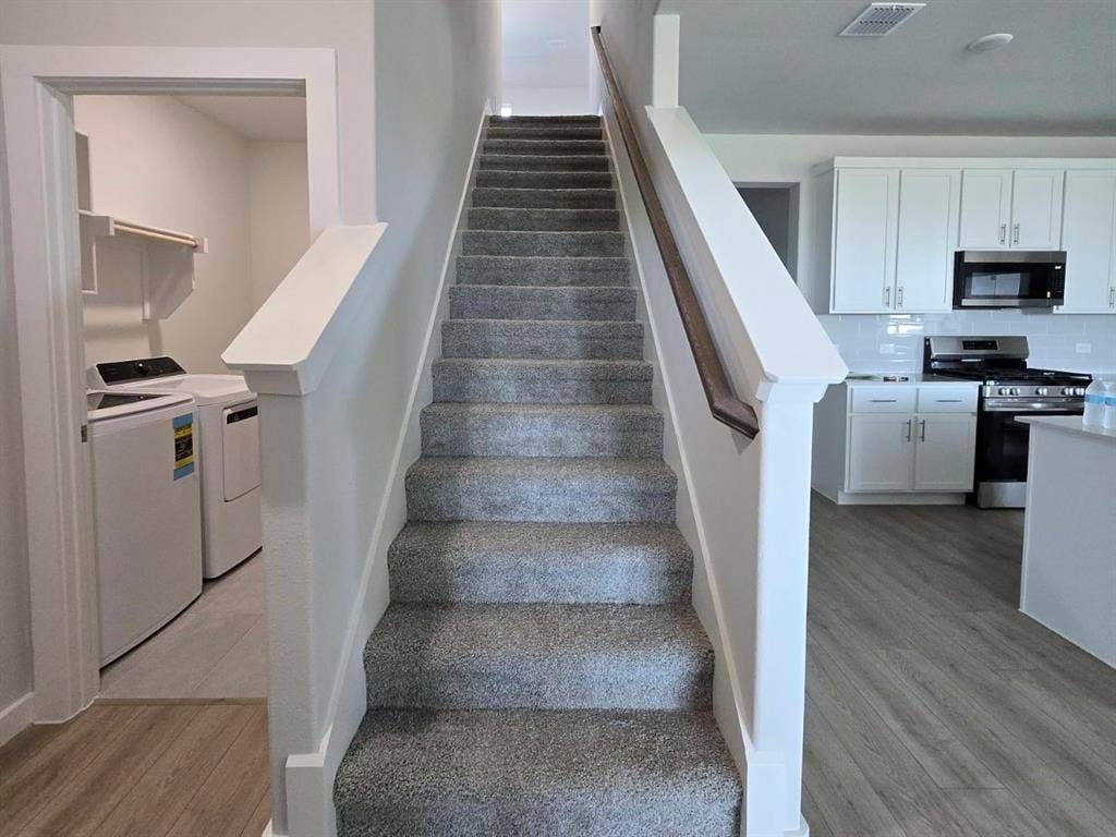 841 Rockcloud Drive, Fort Worth, TX 76052 Carpeted staircase with a wood-finish handrail