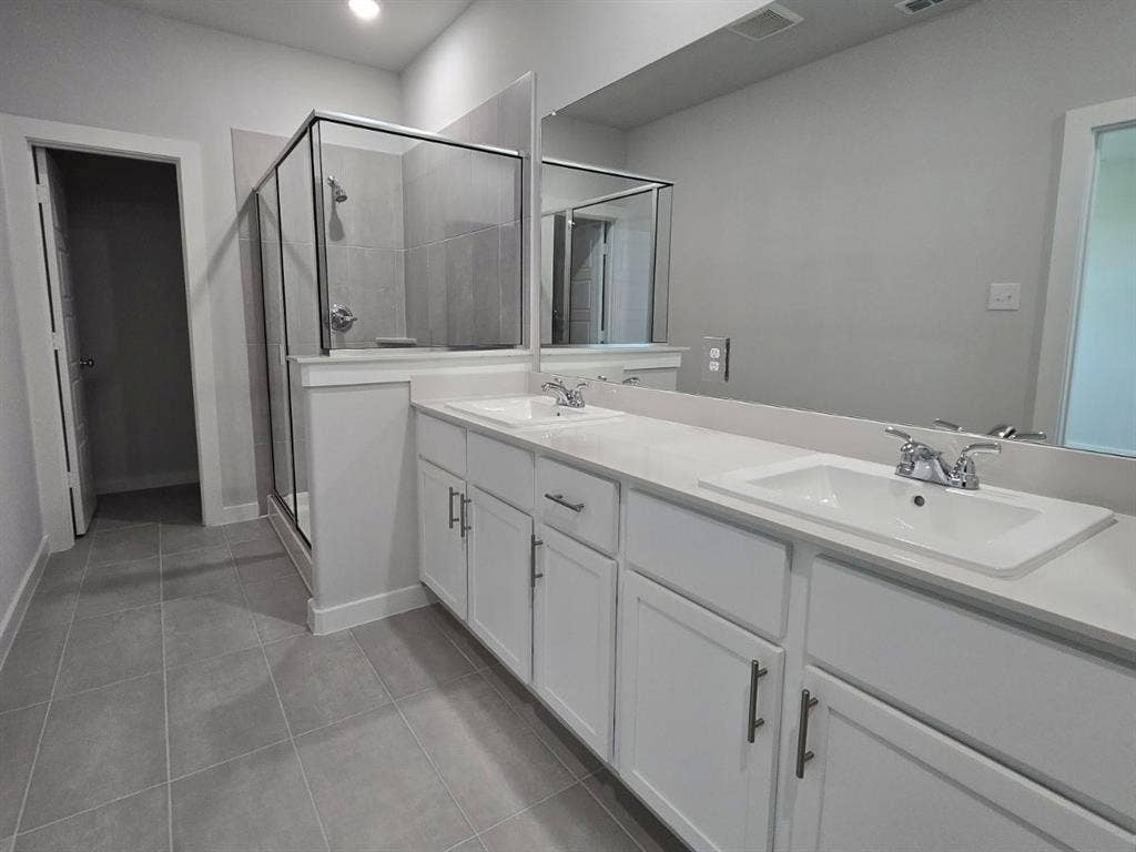 841 Rockcloud Drive, Fort Worth, TX 76052 Dual vanity with white cabinetry and integrated sinks, a glass-enclosed shower, and tile flooring