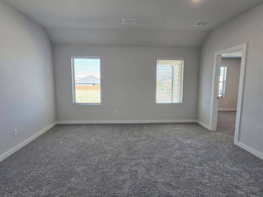 841 Rockcloud Drive, Fort Worth, TX 76052 Spacious room featuring vaulted ceilings, neutral wall tones, two windows with horizontal blinds, and grey carpeting