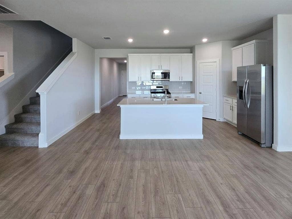 841 Rockcloud Drive, Fort Worth, TX 76052 Contemporary kitchen with stainless steel appliances, white cabinetry, and a central island