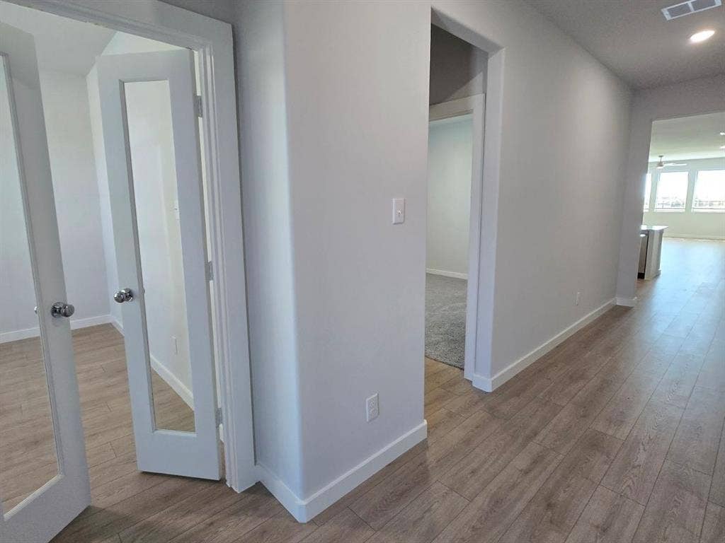 841 Rockcloud Drive, Fort Worth, TX 76052 Wood-finish flooring throughout, bright white trim, and light gray wall paint