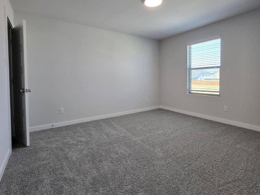 841 Rockcloud Drive, Fort Worth, TX 76052 Neutral-toned carpeting, light gray wall paint, and a single window with horizontal blinds
