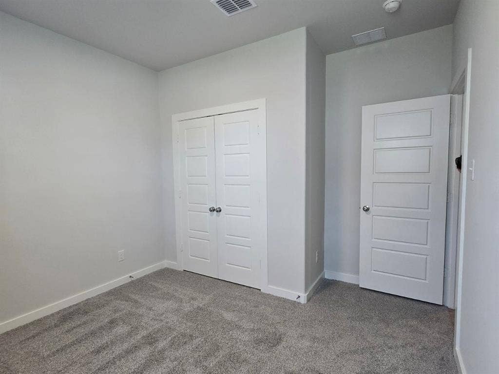 841 Rockcloud Drive, Fort Worth, TX 76052 Wall-to-wall carpeting in a neutral tone, white baseboards, and two paneled doors with chrome hardware