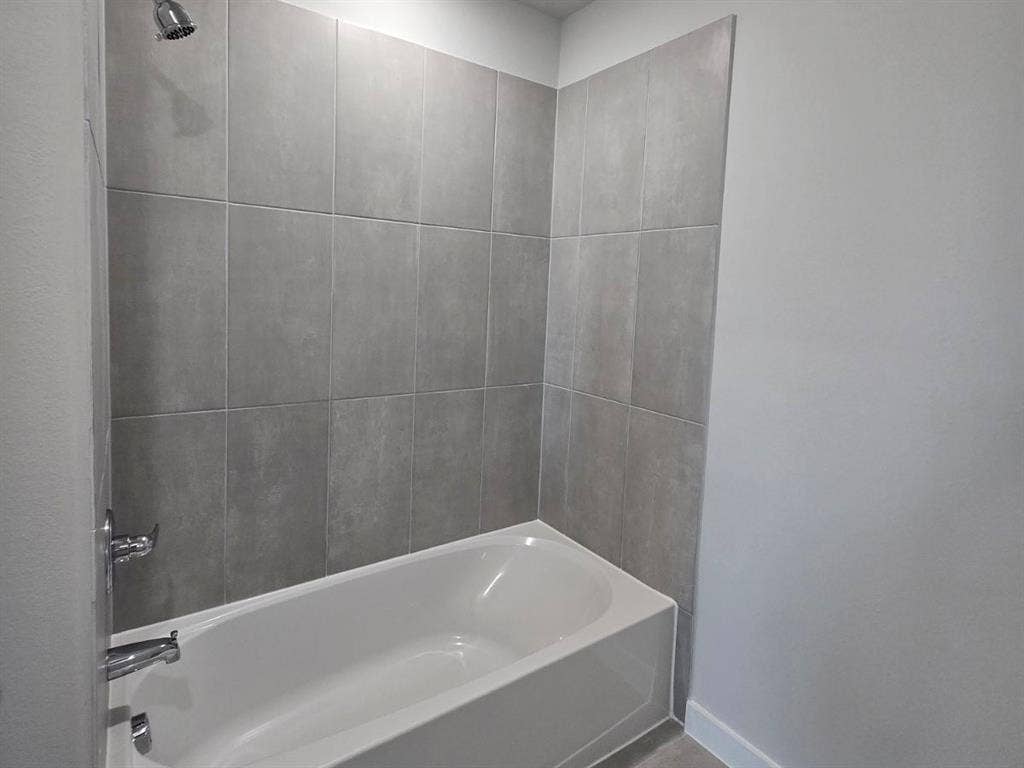 841 Rockcloud Drive, Fort Worth, TX 76052 Bathtub with gray subway tile surround and chrome fixtures