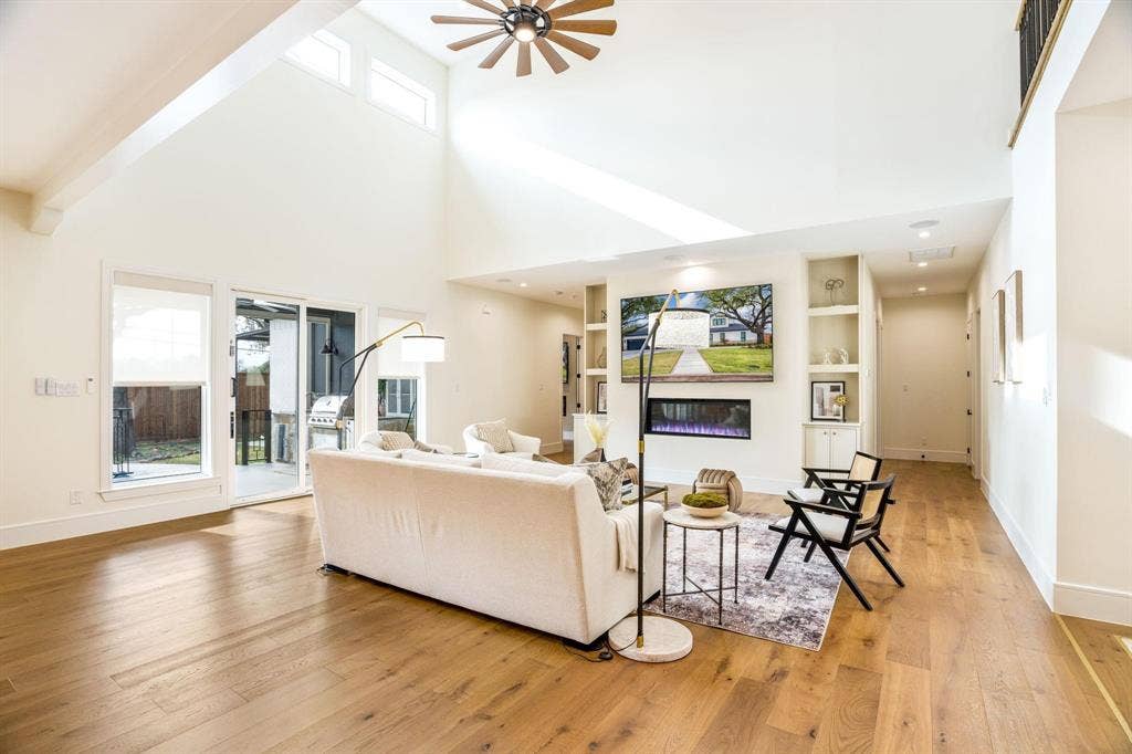 12007 Quincy Lane, Dallas, TX 75230 Vaulted ceiling, wood-finish flooring, built-in shelving, electric fireplace, and sliding glass door