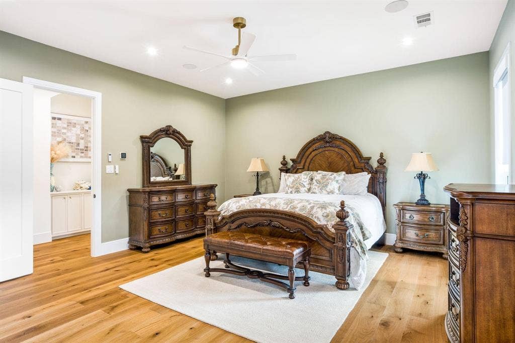 12007 Quincy Lane, Dallas, TX 75230 Hardwood flooring, recessed lighting, ceiling fan with brushed gold accents, light green wall paint, and a white sliding door