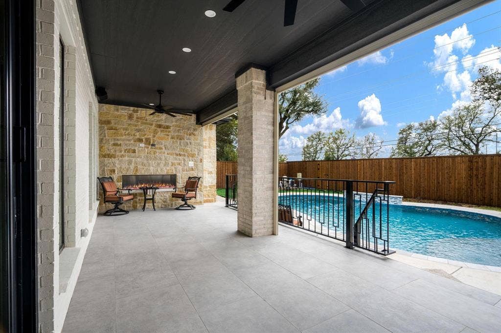 12007 Quincy Lane, Dallas, TX 75230 Covered patio with recessed lighting, ceiling fan, stone-clad wall, linear fireplace, and direct access to a swimming pool