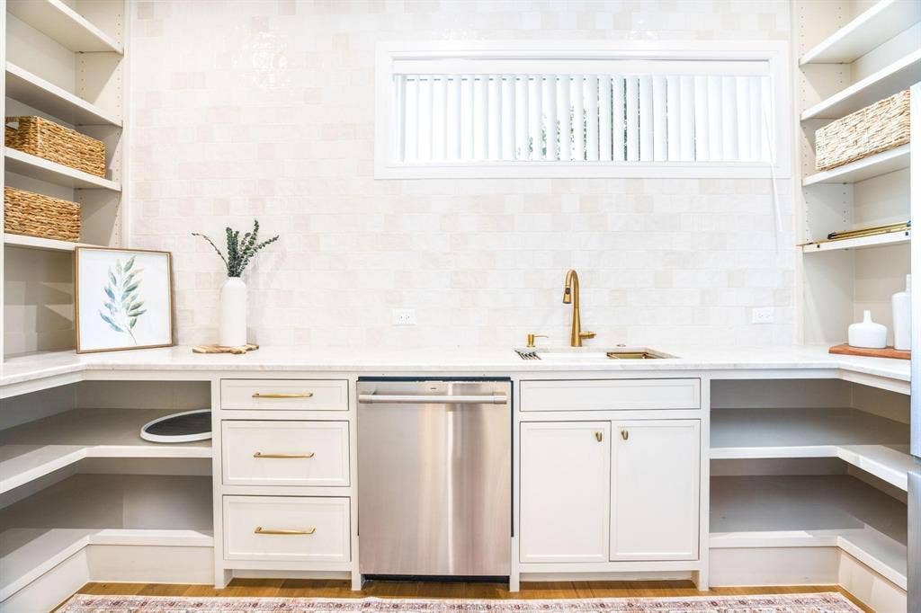 12007 Quincy Lane, Dallas, TX 75230 White cabinetry with gold-tone hardware, integrated sink with gold-tone faucet, and a stainless steel dishwasher