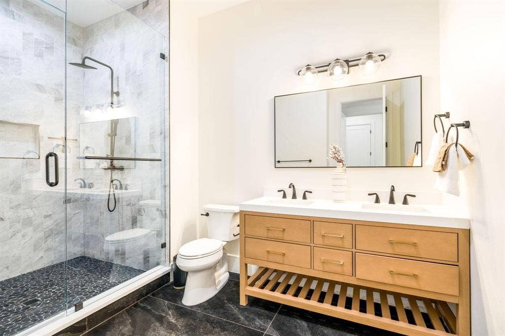12007 Quincy Lane, Dallas, TX 75230 Glass-enclosed shower with stone tile surround and pebbled floor