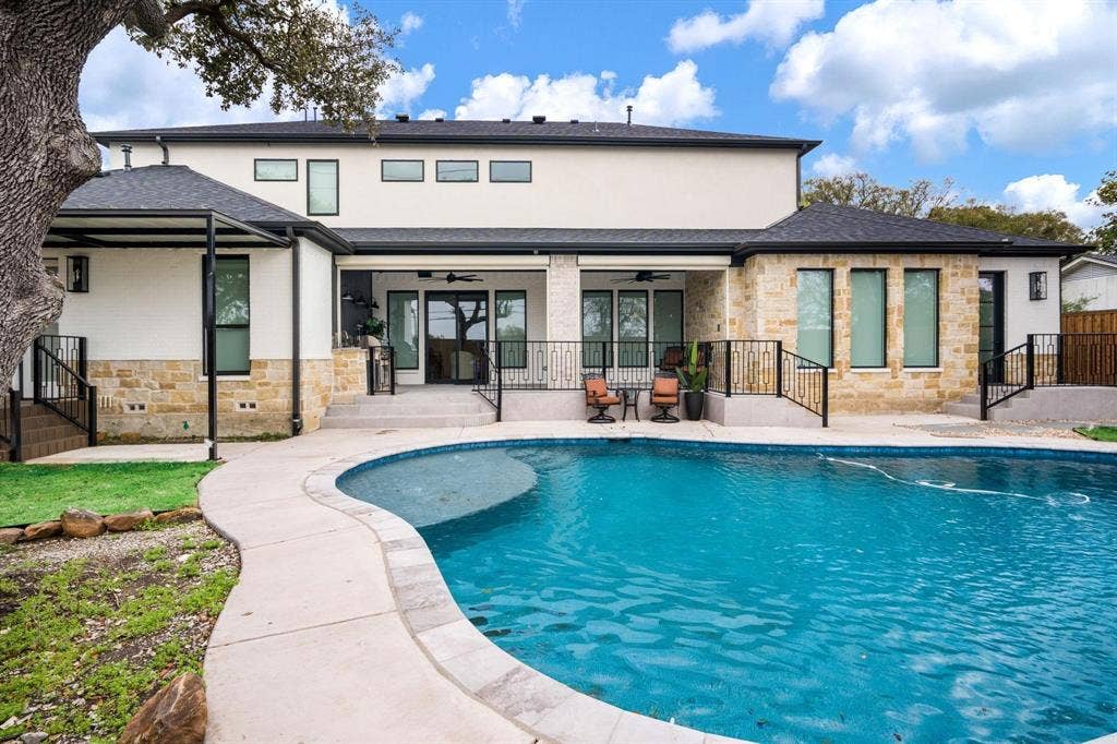 12007 Quincy Lane, Dallas, TX 75230 Outdoor swimming pool with a curved border, stone and stucco exterior, covered patio, and multi-level landscaping