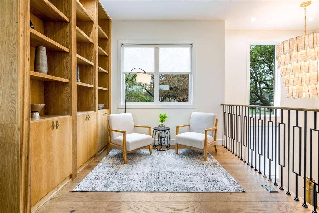 12007 Quincy Lane, Dallas, TX 75230 Built-in shelving with lower cabinetry, wood-finish flooring, and black metal balusters with geometric details