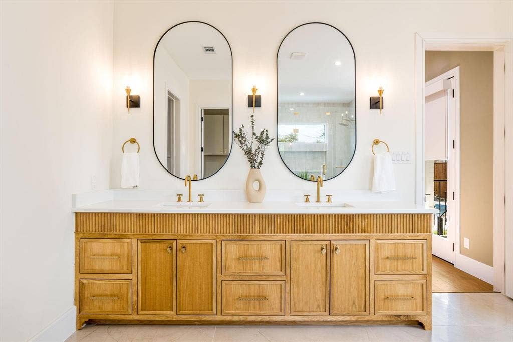12007 Quincy Lane, Dallas, TX 75230 Dual vanity with a wood-finish cabinet and white countertop