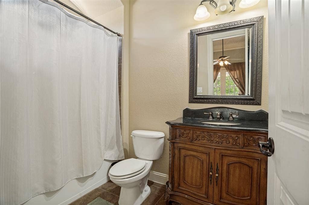 1250 Packsaddle Trail, Prosper, TX 75078 Traditional vanity with carved wood details, a dark countertop, and an undermount sink