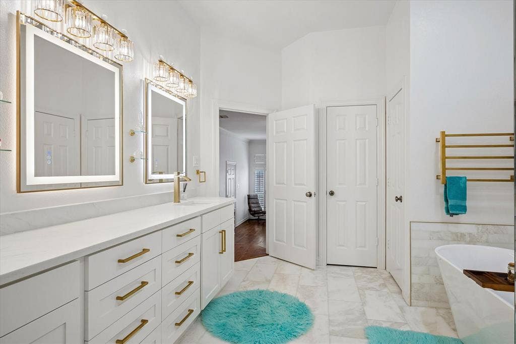 2916 Thomas Avenue, Dallas, TX 75204 Dual vanity with white cabinetry and gold-finish hardware