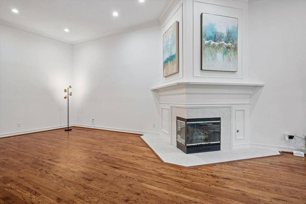 2916 Thomas Avenue, Dallas, TX 75204 Hardwood flooring, recessed lighting, corner fireplace with a stone surround, and detailed crown molding