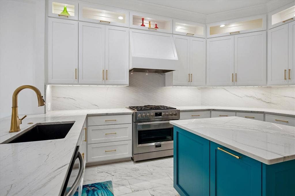 2916 Thomas Avenue, Dallas, TX 75204 Sophisticated kitchen featuring white cabinetry with brushed nickel hardware, marble-finish countertops, and a teal-finished island with matching countertop surface