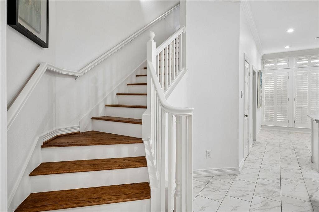 2916 Thomas Avenue, Dallas, TX 75204 Staircase with wood-finish treads and white risers, white balusters, and a white handrail