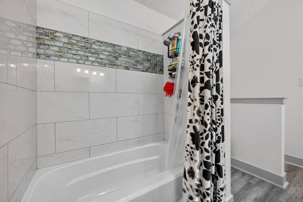 Large primary bathroom with dual vanities and large tub