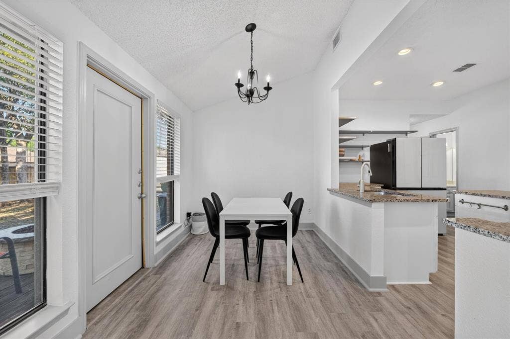 The dining area flows seamlessly into the kitchen, creating an inviting, open concept space perfect for everyday meals and entertaining.