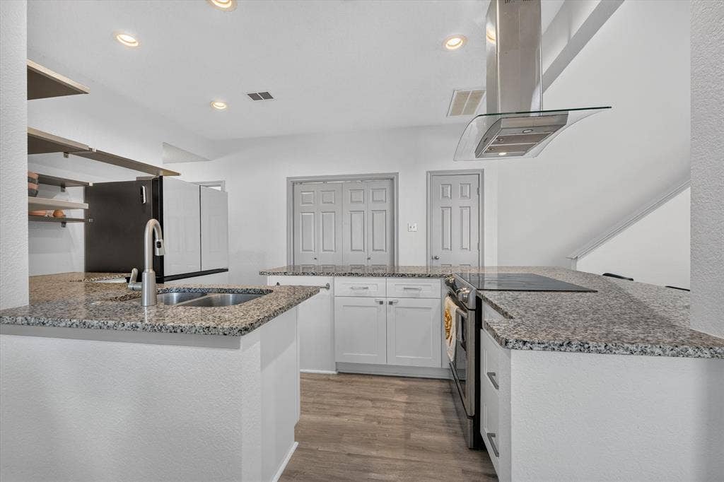 The kitchen features beautiful granite countertops, abundant cabinet storage, and an open layout that blends seamlessly with the dining and living areas.
