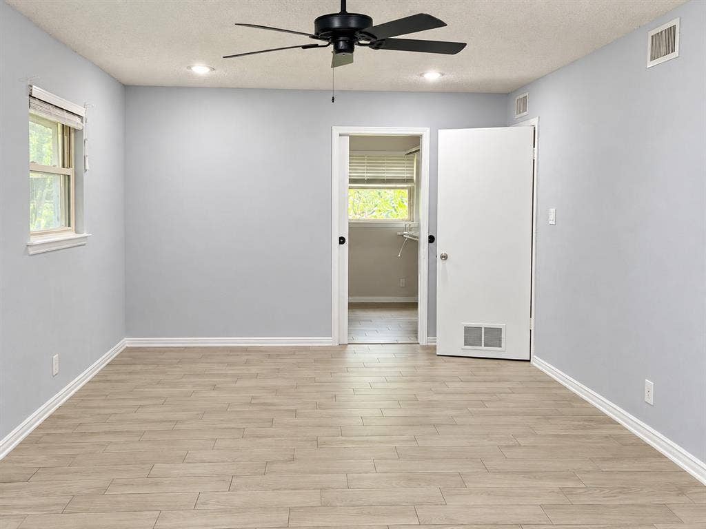 Room featuring wood-finish flooring, recessed lighting, and a black ceiling fan