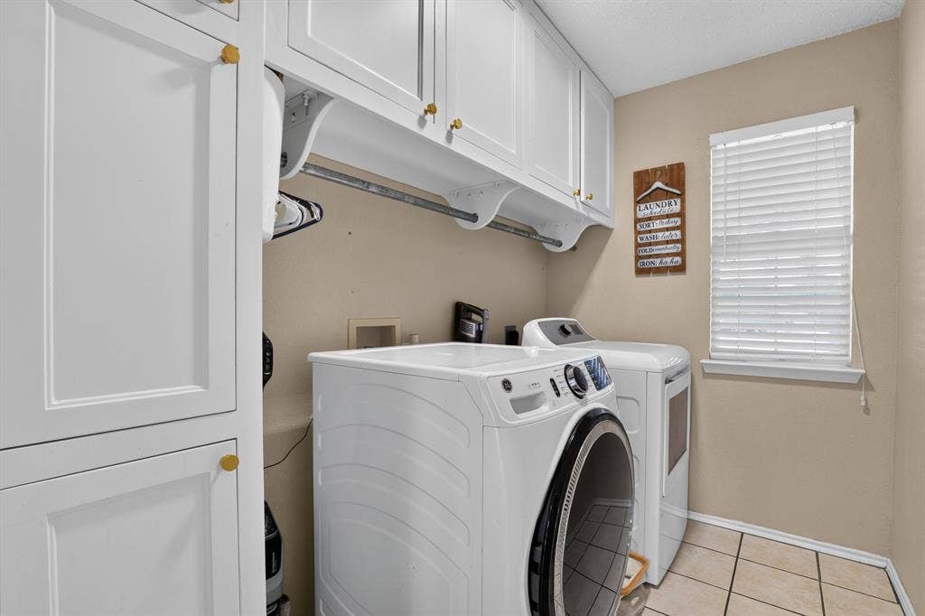 White shaker-style cabinetry with gold-tone hardware, a built-in hanging rod, and ceramic tile flooring