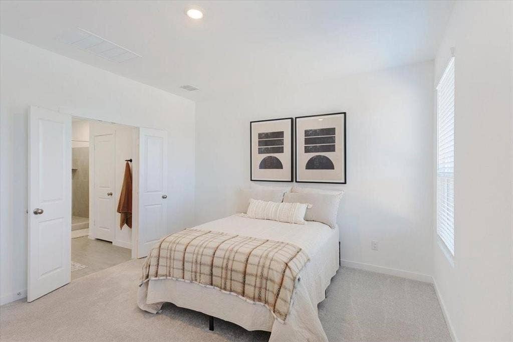 Recessed lighting, light-toned carpeting, and a window with blinds