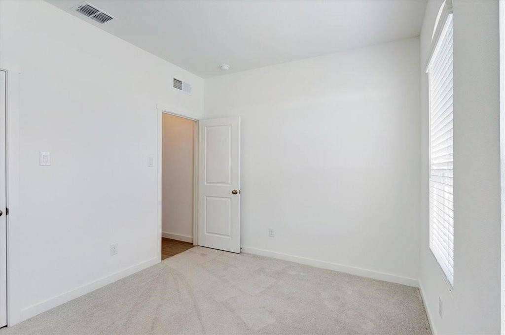 Wall-to-wall carpeting, window with blinds, and white interior doors
