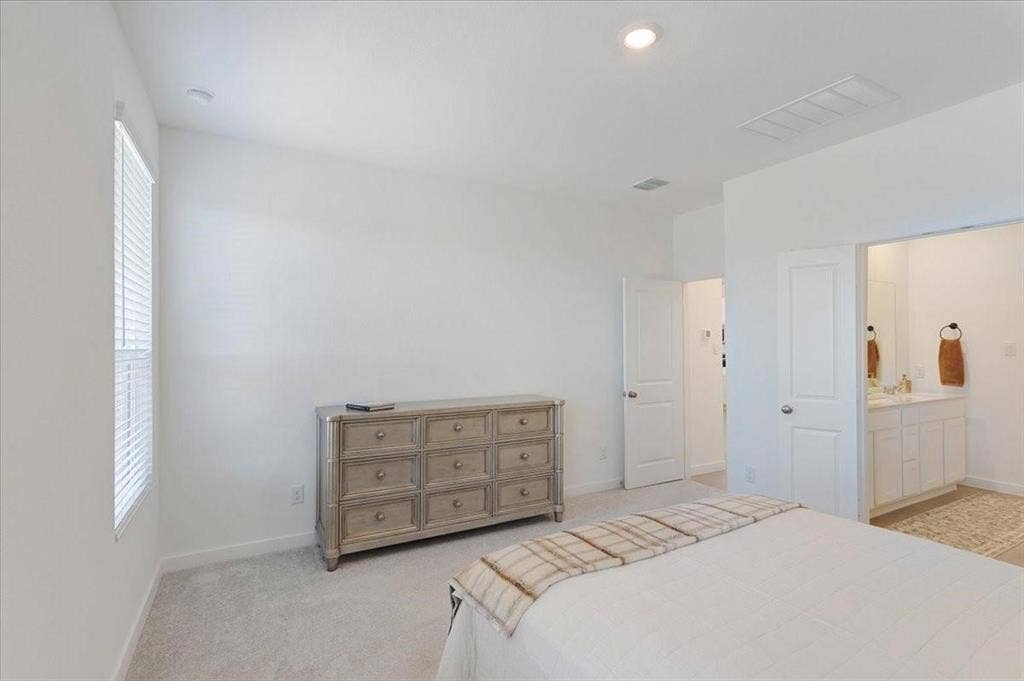Recessed lighting, plush carpet flooring, and a window with blinds